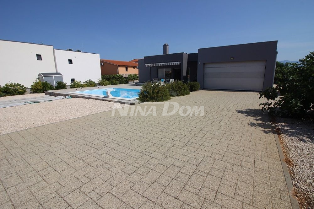 Nicely decorated one-story house with a garage and a swimming pool on a large garden.